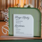 Green striped frame displaying custom wedding invitation with Maggie & Pauly's names and event details
