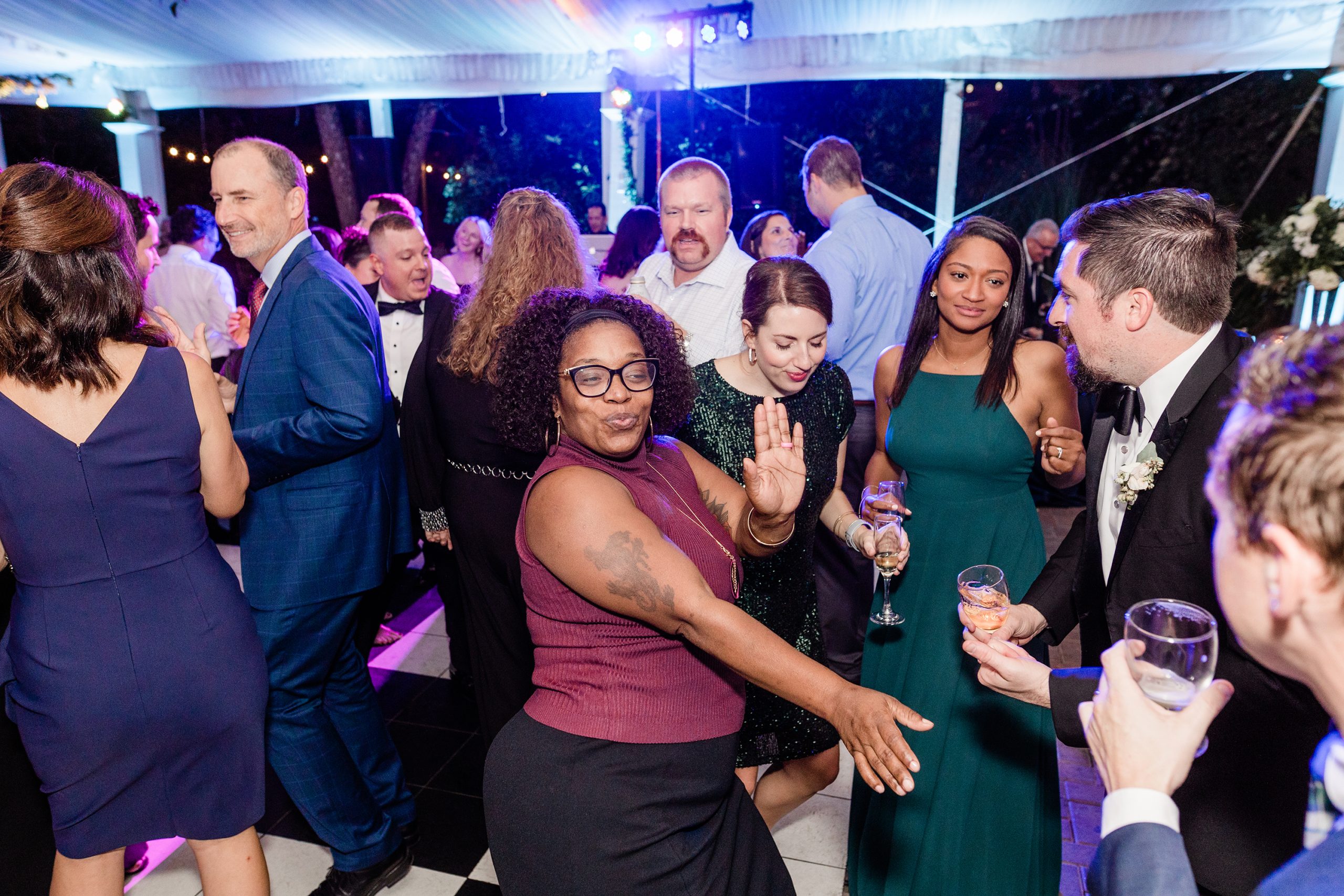 Diverse group of wedding guests dancing and celebrating together at reception