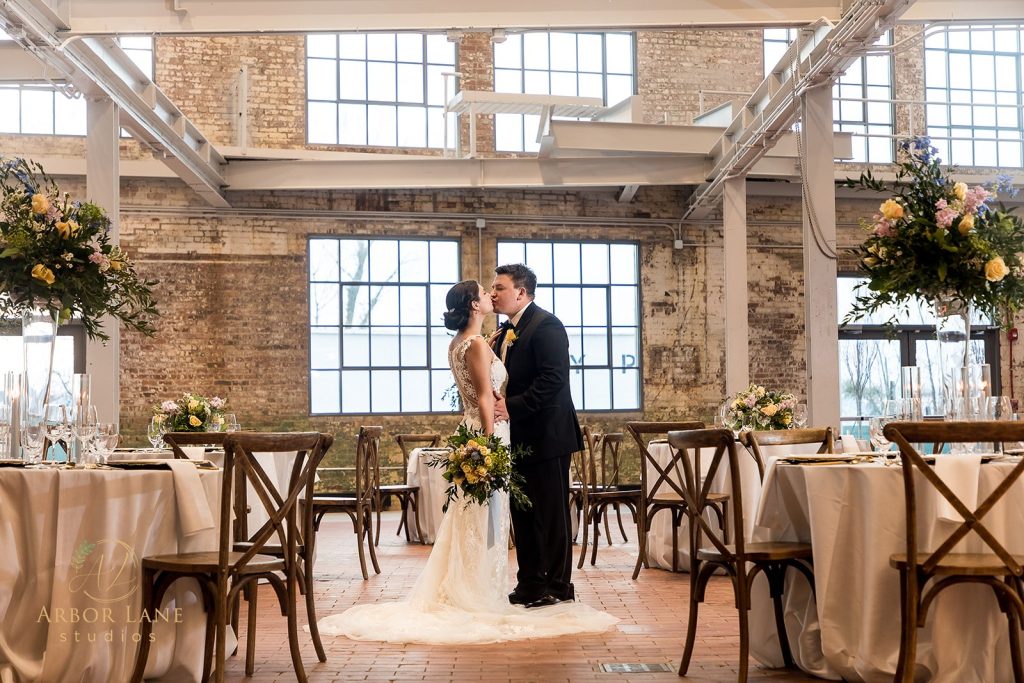 Bride and groom sharing a romantic portrait inside The Packing House in Cambridge, Maryland, showcasing a Boutique Bride wedding reception with elegant floral décor.