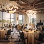Elegant reception venue with marble tables, upholstered chairs, and modern lighting beneath tall windows
