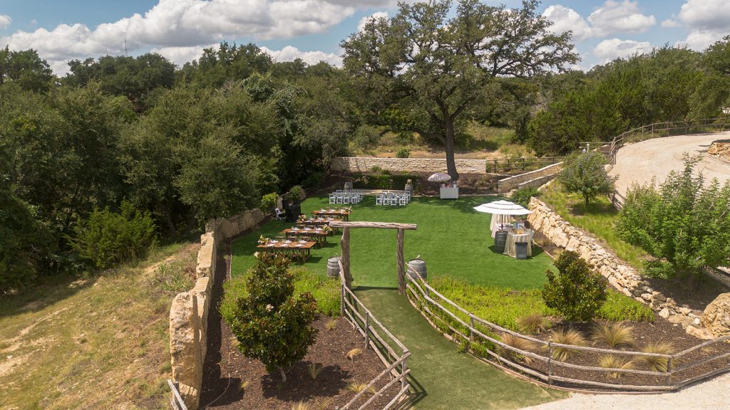 Historic stone amphitheater venue with terraced green lawn and shaded seating areas