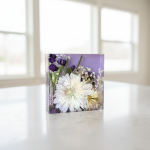Wedding flower preservation in acrylic block with white and purple flowers on marble countertop