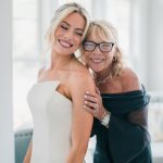 Happy bride and mother share a tender moment before the ceremony