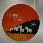 Round orange door hanger with El Paso skyline silhouette and "Home is where our story starts" text