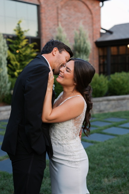 Newlywed couple embracing in garden setting after wedding ceremony