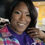 Business owner displaying engagement ring while wearing Raediant Design purple shirt