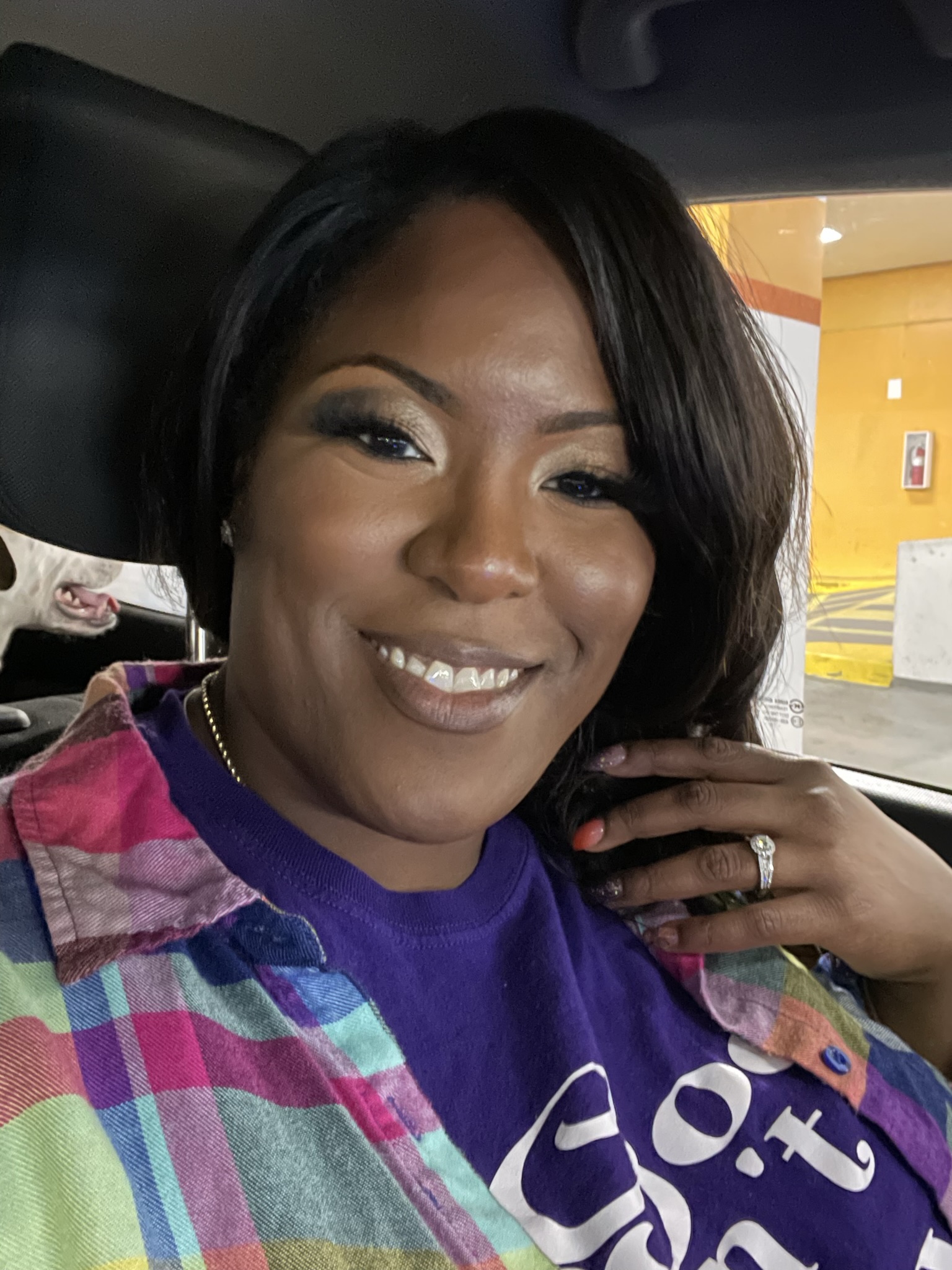 Business owner displaying engagement ring while wearing Raediant Design purple shirt