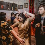 Wedding guests dancing together at reception venue with industrial brick walls and Atlanta United decor