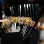 Tiger-themed acrylic drink stirrers arranged in black holder at bar setup