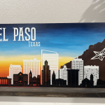 El Paso Texas skyline painting featuring downtown buildings, Franklin Mountains, and star logo against blue and orange sunset sky