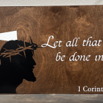 Rustic wooden sign with scripture quote "Let all that you do be done with love" from 1 Corinthians 16:14