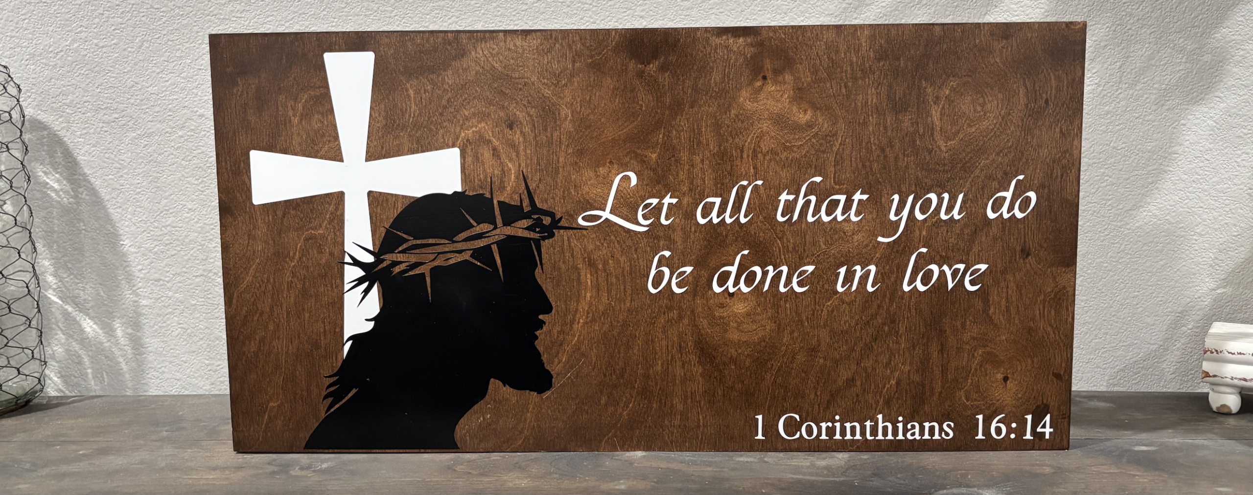 Rustic wooden sign with scripture quote "Let all that you do be done with love" from 1 Corinthians 16:14