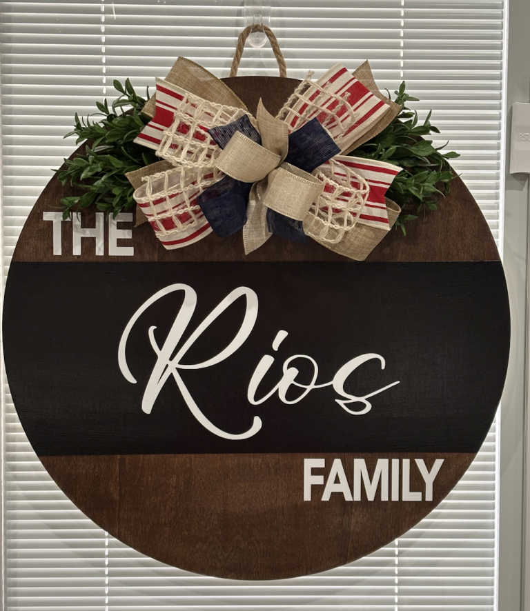 Personalized round door sign reading "The Rios Family" with patriotic red, white, and blue burlap bow