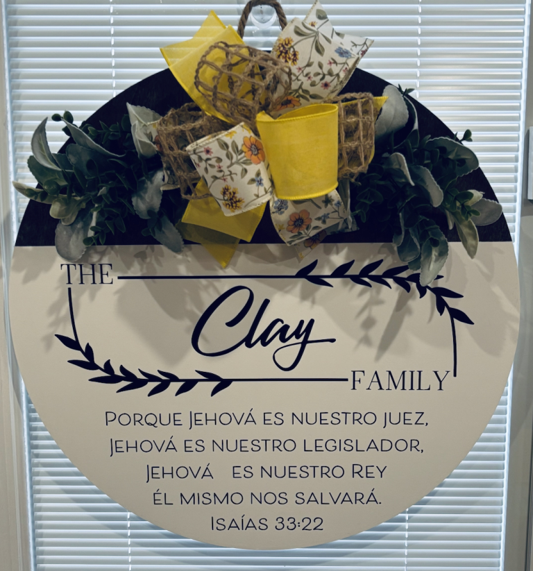 Personalized door sign with "The Clay Family" text, floral ribbon bow, and Spanish Bible verse from Isaiah 33:22