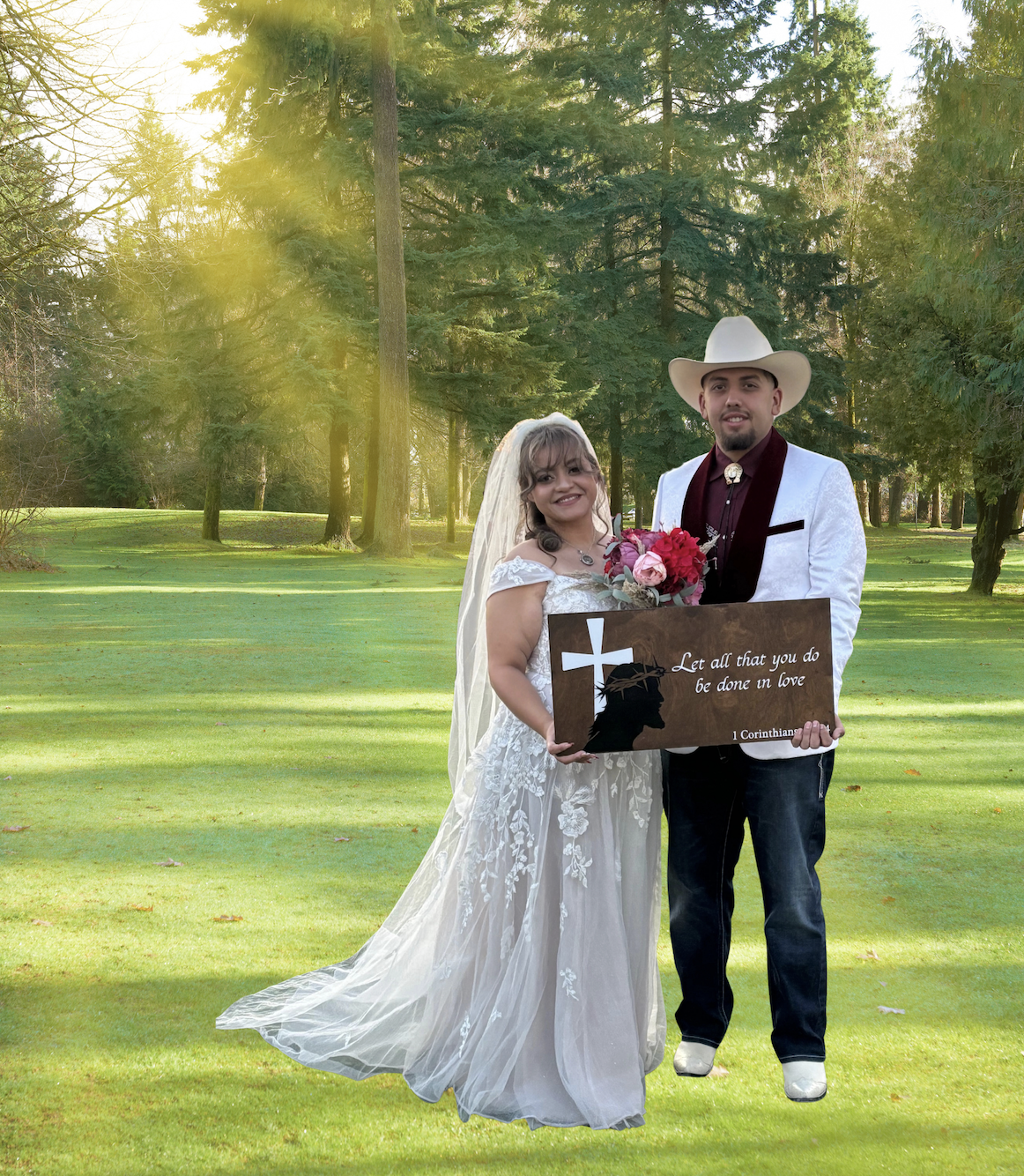 Bride in white lace gown with veil and groom in cowboy hat holding scripture sign on sunlit golf course