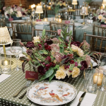 Elegant table setting with gingham tablecloth, floral centerpiece, and fine china plates