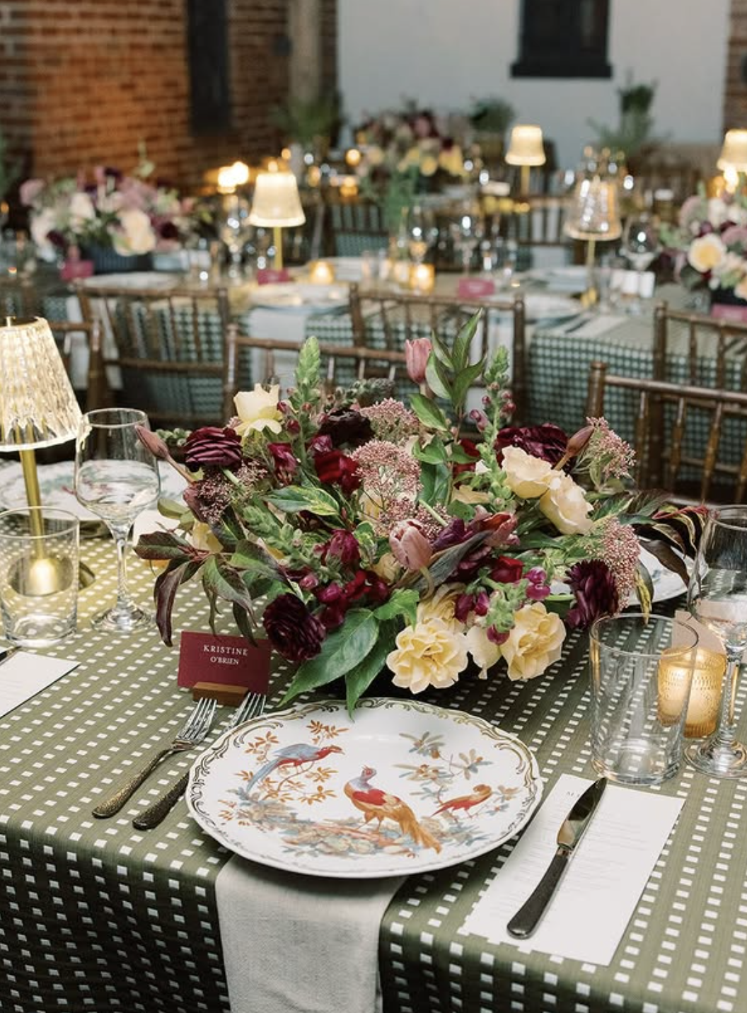 Elegant table setting with gingham tablecloth, floral centerpiece, and fine china plates