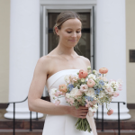 Bride in strapless white gown holding pastel bouquet of pink, blue, and white flowers