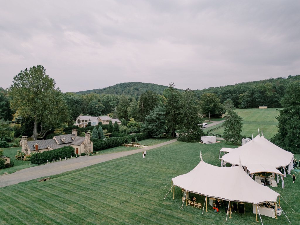Wedding venue estate with twin peaked tents, stone cottages, and tree-lined driveway in Northern Virginia countryside