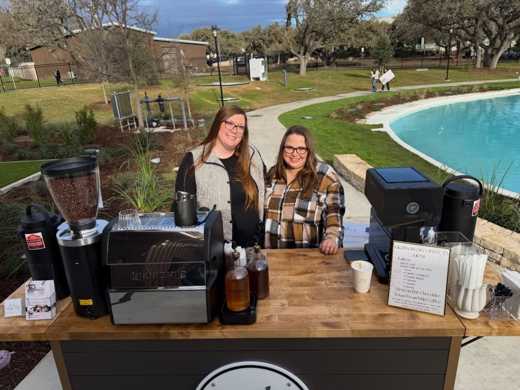 Two baristas operate mobile espresso bar beside pool at outdoor reception venue