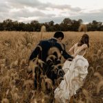 Husband and wife in grassy knoll after wedding ceremony