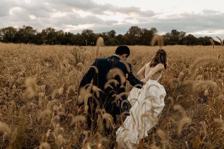 Husband and wife in grassy knoll after wedding ceremony