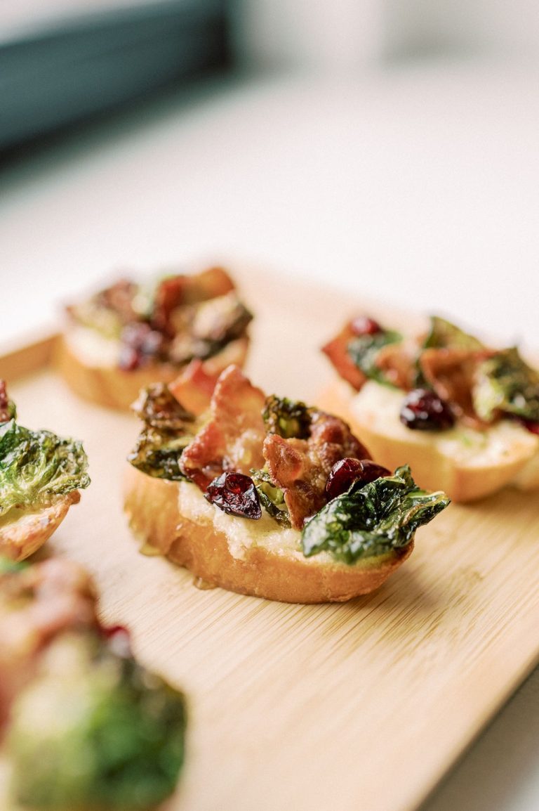 Crispy bruschetta topped with bacon, cranberries, and greens on toasted baguette slices