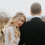 Bride with soft curled blonde hair and natural makeup wearing a lace wedding dress with groom in Northern Virginia