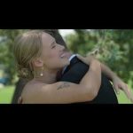 Bride joyfully embracing groom outdoors in natural garden setting