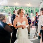 Bride laughing and celebrating with guests at indoor wedding reception
