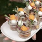 Mini desserts served in individual glass cups with fresh fruit garnishes
