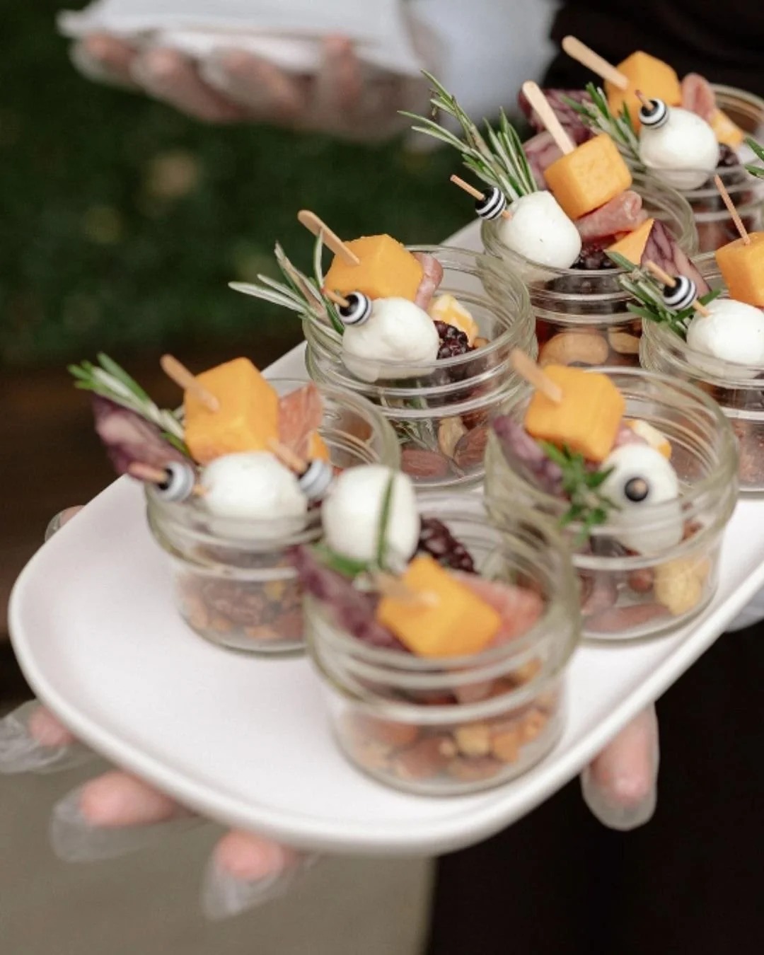 Mini desserts served in individual glass cups with fresh fruit garnishes