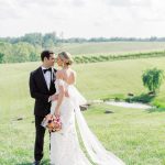 Bride and groom embracing in Northern Virginia vineyard with rolling hills in background