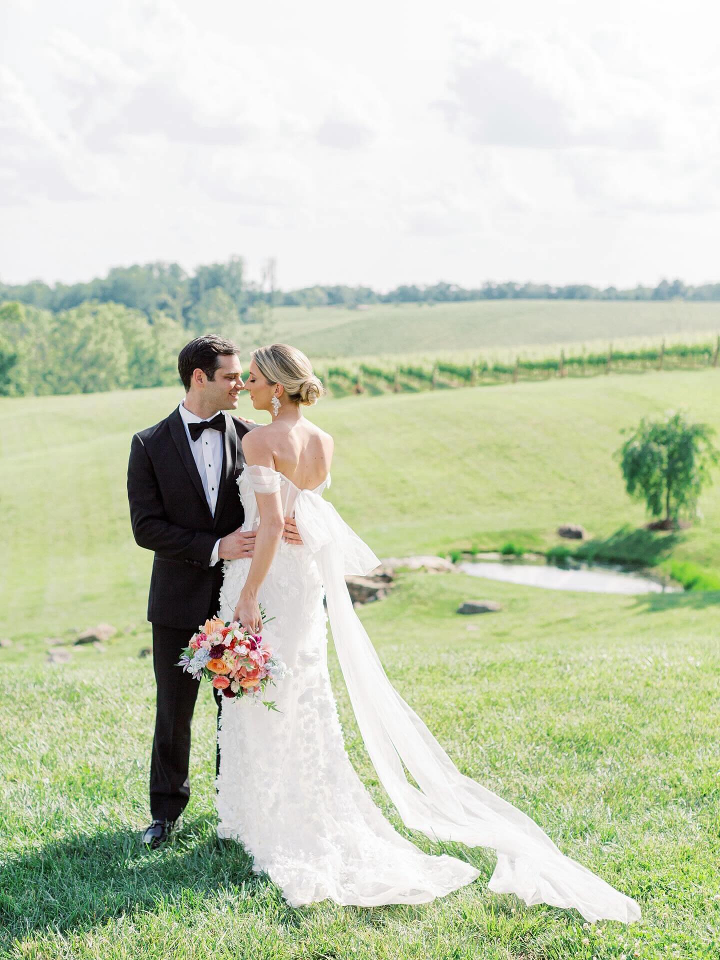 Bride and groom embracing in Northern Virginia vineyard with rolling hills in background