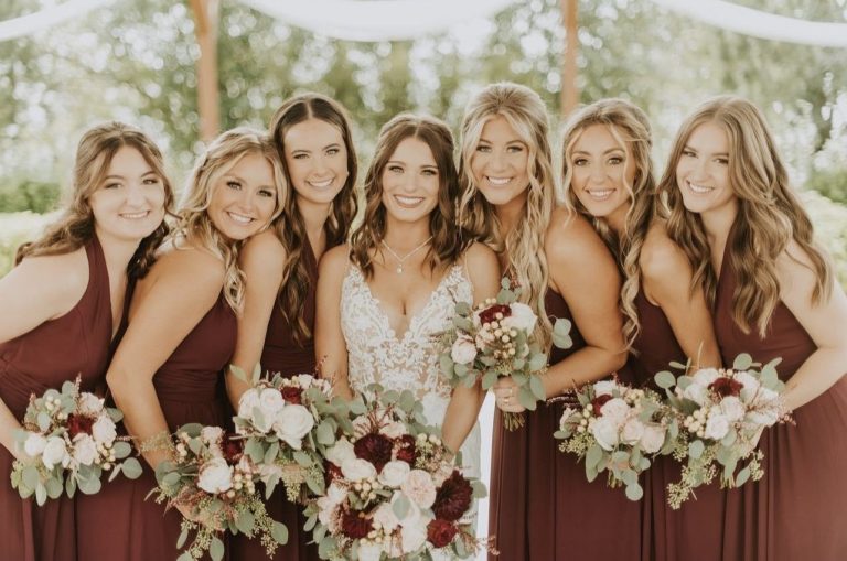 Bridal party with coordinated hair and makeup showing burgundy and ivory wedding color scheme