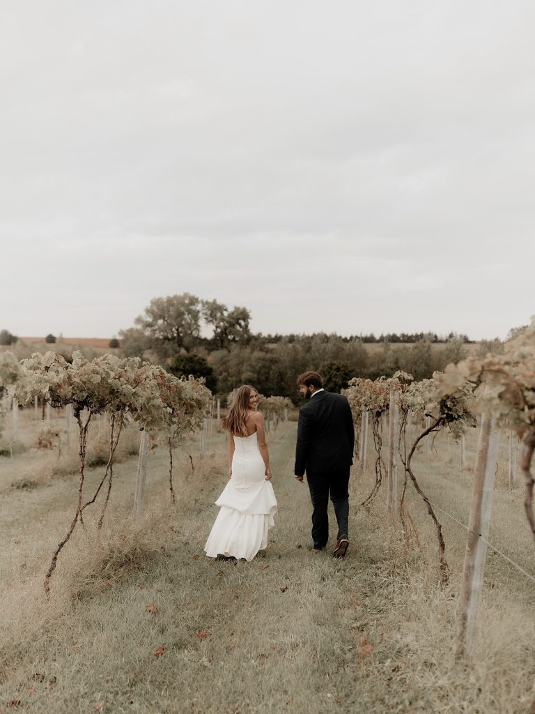Couple walking through outdoor vineyard wedding venue near Lincoln, Nebraska
