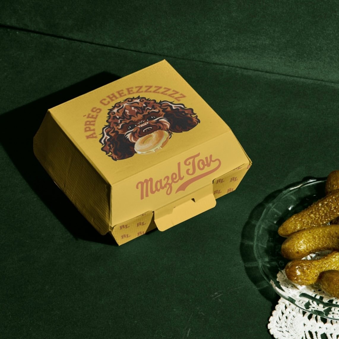 Yellow matchbox with custom monogram seal on deep green velvet backdrop