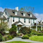 White colonial-style mansion with manicured gardens and blue sky, a Northern Virginia wedding venue