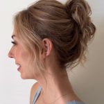 Side view of elegant bridal updo with loose tendrils and soft volume