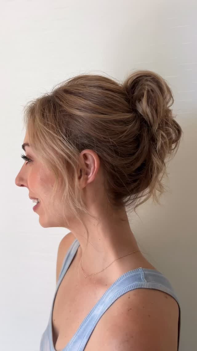 Side view of elegant bridal updo with loose tendrils and soft volume
