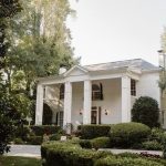 White Greek Revival-style mansion with tall columns and manicured landscaping, wedding reception venue in Alpharetta