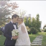 Couple sharing intimate moment in garden setting with white bridal bouquet