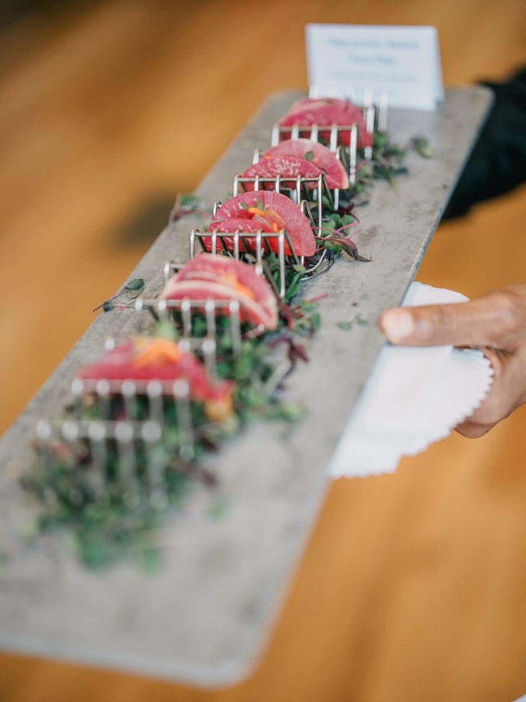 Seared tuna slices arranged on slate platter with microgreens, served at catered event