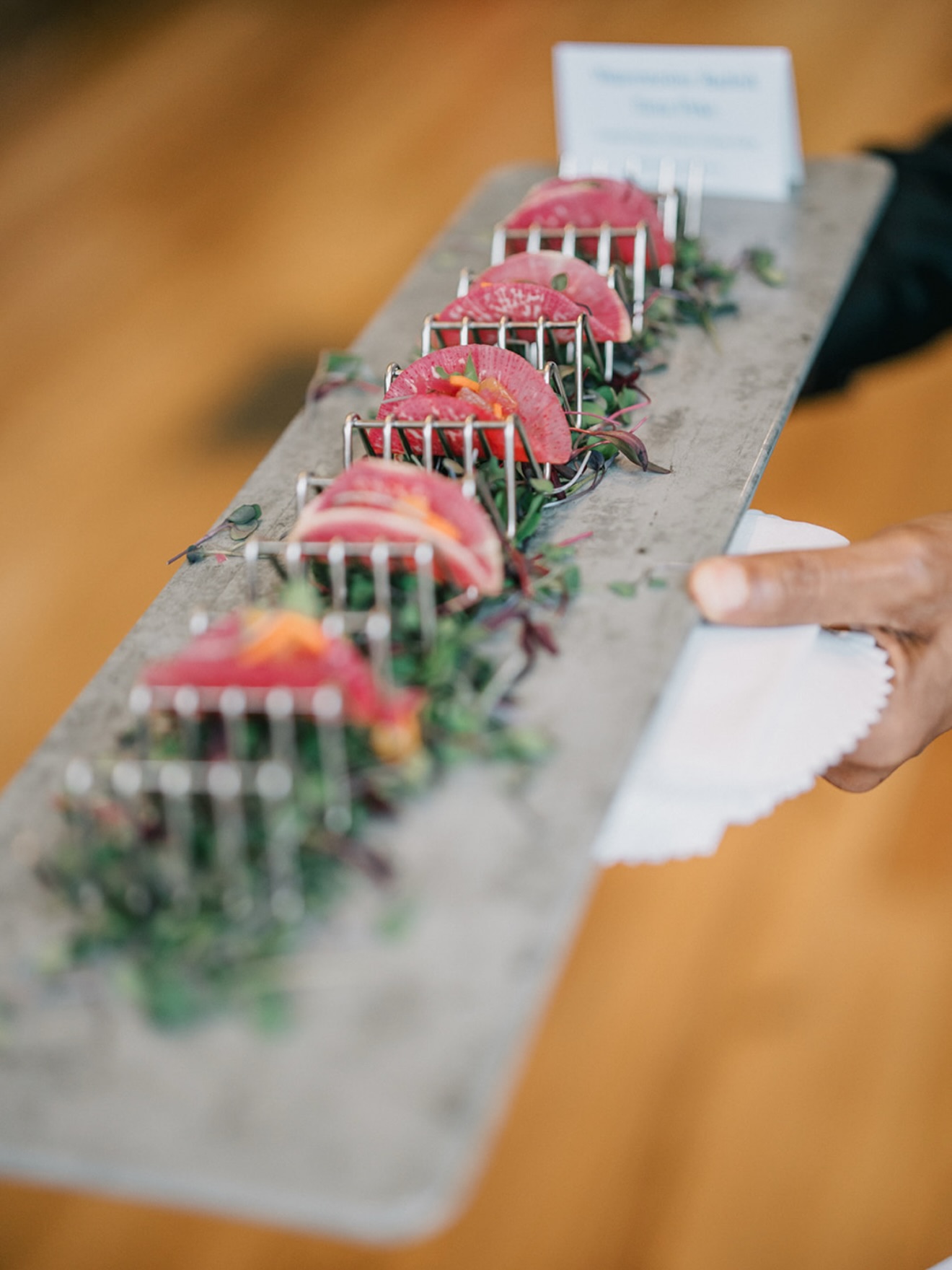 Seared tuna slices arranged on slate platter with microgreens, served at catered event