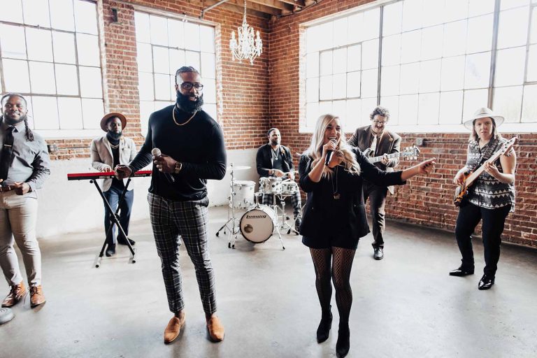 Two lead vocalists performing with Diamond Empire Band in industrial brick venue