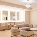 Luxurious bridal suite featuring curved velvet furniture, brass details, and illuminated vanity mirrors