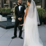 Bride and groom in wedding attire standing together on rooftop terrace