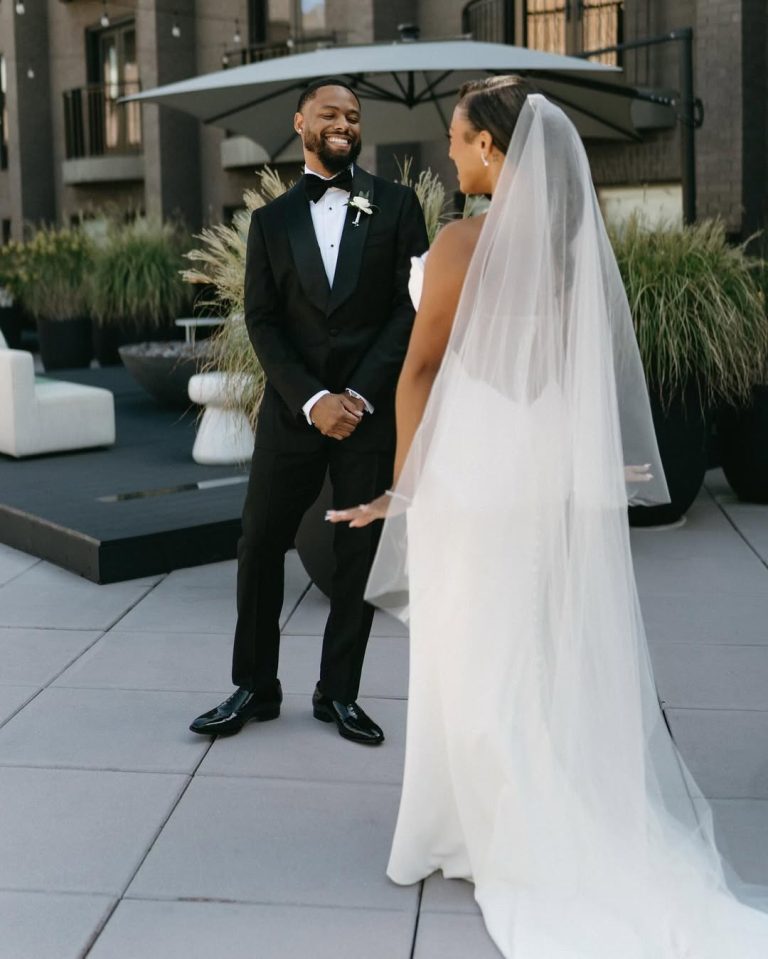 Bride and groom in wedding attire standing together on rooftop terrace