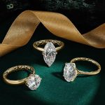Three gold engagement rings with marquise, oval, and round diamonds featuring geometric textured bands on emerald velvet
