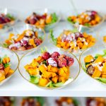 Colorful appetizer cups filled with tropical fruit salsa and garnishes